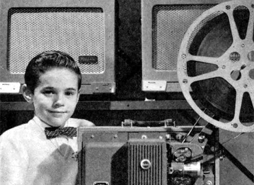 Kid with bowtie and 16mm projector. 